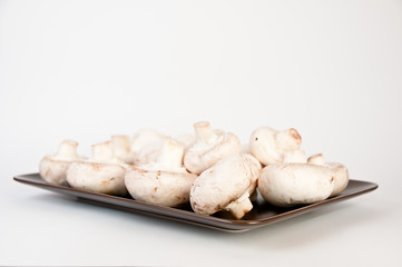 White mushrooms on a brown plate