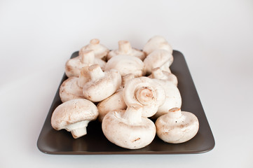 White mushrooms on a brown plate