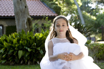 Beautiful young girl in white dress sitting on bench