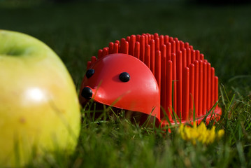 red plastic penholder hedgehog finds a natural apple