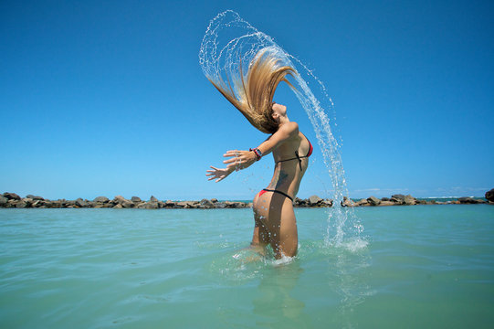 Bikini girl tossing hair creating interesting water effect