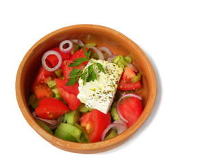Greek salad in a clay plate isolated on a white background