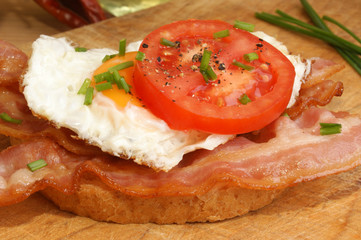 eine Brotscheibe mit Speck und Spiegelei