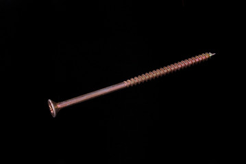 Brass wood screw on a black background.