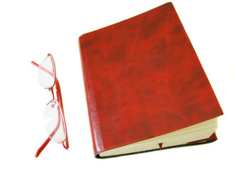Notebook made of a red skin and glasses