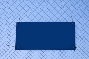 blank sign for copy tied to a wire fence