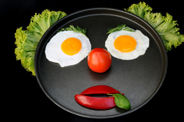 Clown face from fried eggs and vegetables