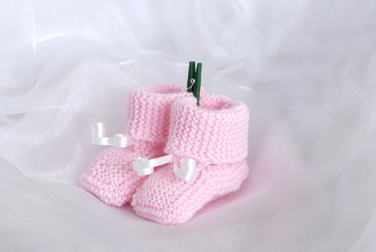 chaussons de bébé rose sur fond de mousseline blanc