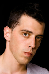 Close up portrait of a handsome young man on black background