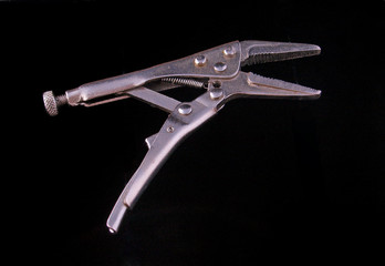 Chrome vice grip on a black background.