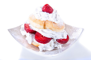 Delicious freshly baked donut with cream and strawberry