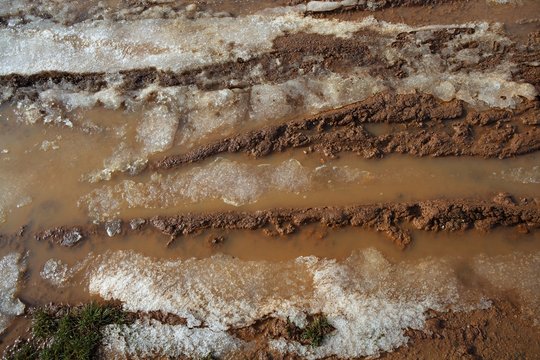 Ice On Mud Red Clay Soil Road With Tyres Lines