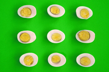 nine sliced eggs on green - obrazy, fototapety, plakaty