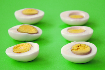 Fototapeta na wymiar six sliced eggs on green