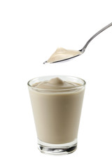 bicchiere con cucchiaio di yogurt alla nocciola