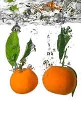 Schilderijen op glas mandarijn in water gevallen met bubbels op wit © artjazz