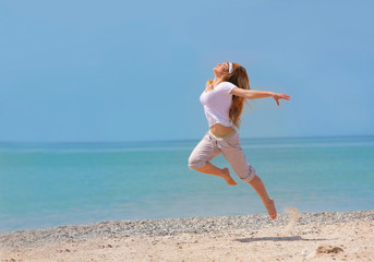 young happy girl jumping on beach