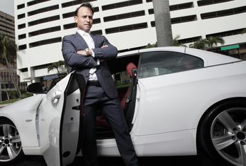 Businessman standing by his car