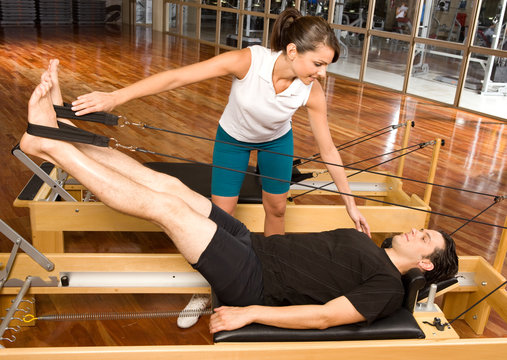 Girl Assisting Man During Pilates