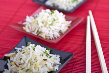 Reis mit Essstäbchen auf roter Matte