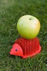 red palstic hedgehog with green apple on its back