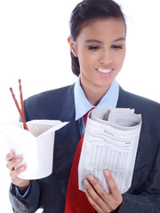 management trainee reading newspaper with a box of noodles