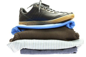 Fototapeta na wymiar sports shoes lying on the mountain of clothes isolated on white