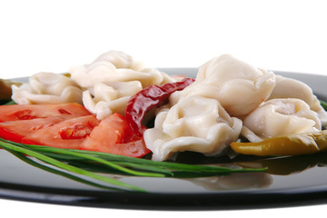 dumplings served with vegetables on black