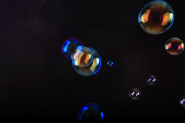 Soap bubbles on black background .