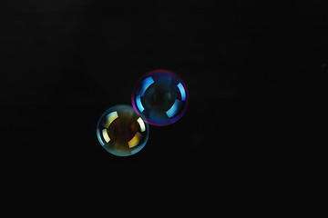 Soap bubbles on black background .