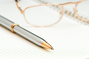 Fototapeta premium Pen and eye glasses on the page