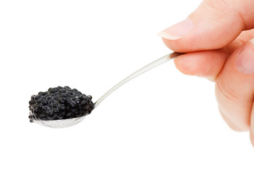 Black caviar on a spoon isolated on white