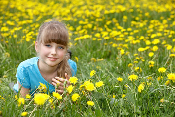 Little girl lying on grass in flower.