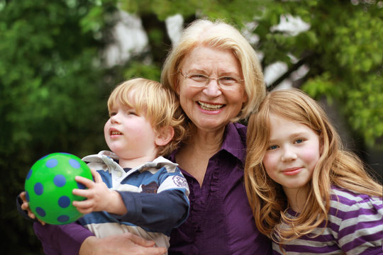 glückliche Oma mit ihren beiden Enkelkindern