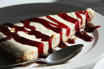 Closeup of cheese cake with jam on a plate