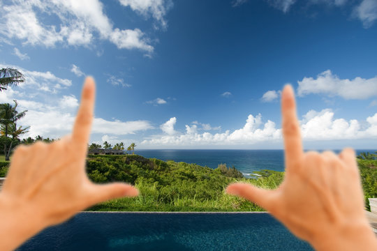Hands Framing Breathtaking Hawaiian Ocean View Deck and Pool