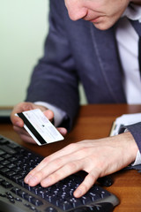 hands holding credit card and pressing a keys of keyboard