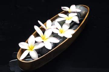 White plumeria and therapy stones in wooden tray