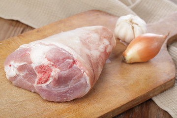 Raw pork leg on a cutting board