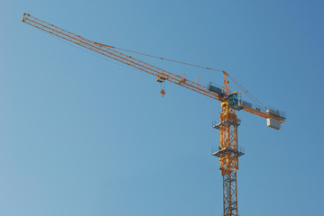 yellow single derrick crane with blue sky
