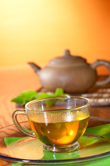 Cup with greean tea and clay teapot