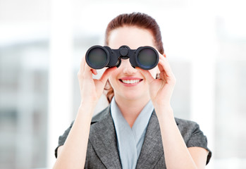 Attractive businesswoman using binoculars