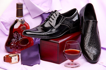Set of male shoes, bottle and glass of brandy, and wristwatch