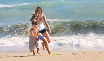 happy mother and son playing on beach