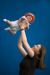 young woman throws up the baby in orange bucket hat