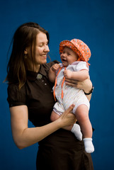woman in brown dress with baby in orange bucket hat