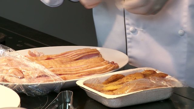 Koch arbeitet mit Schinken und Kochbananen
