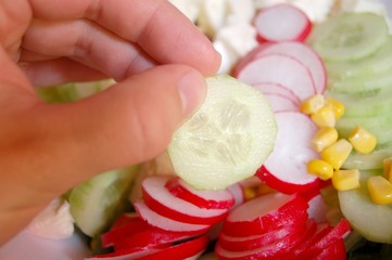 Hand mit Gurkenscheibe