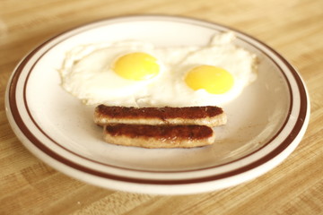 breakfast of eggs sunnyside up and sausage links