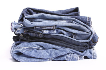 Stack of folded blue jeans on white